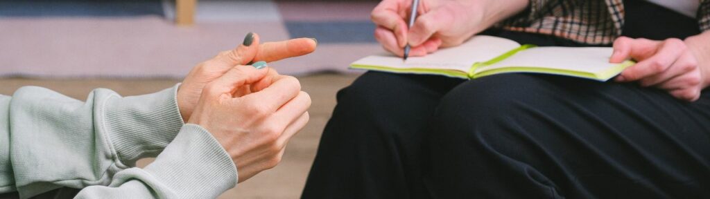 Terapeuta con paciente, el terapeuta escribe en una libreta